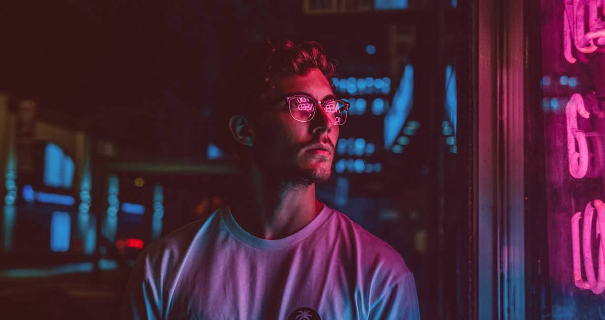 Jeune homme devant un magasin. Ambiance colorée rose et bleu