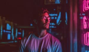 Jeune homme devant un magasin. Ambiance colorée rose et bleu